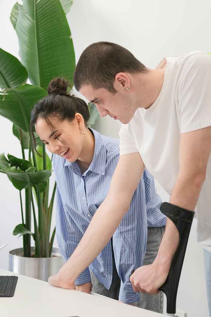 A support worker helping a NDIS participant in an office