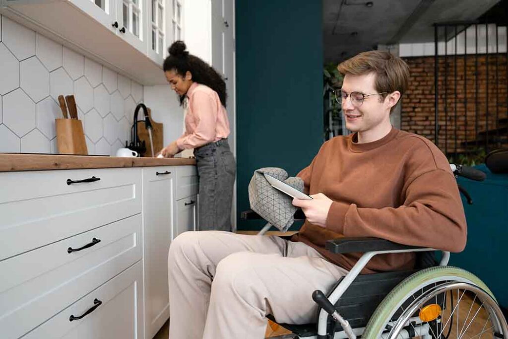 A support worker helping a NDIS client in a kitchen